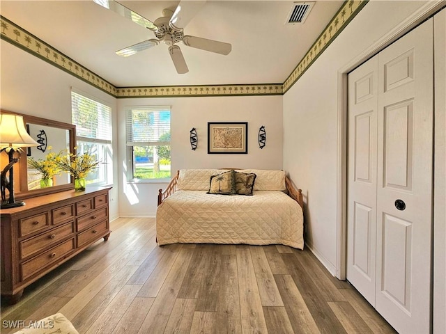 bedroom with hardwood / wood-style flooring, ceiling fan, and a closet