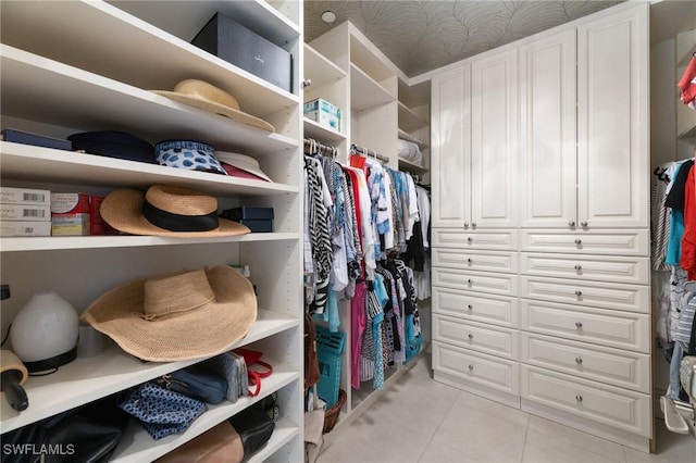 walk in closet with light tile patterned floors