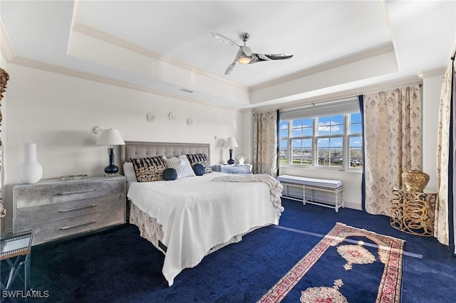 bedroom featuring crown molding, ceiling fan, a raised ceiling, and dark colored carpet