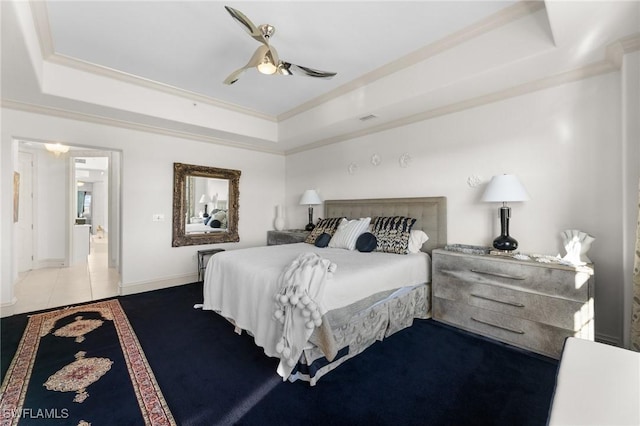 bedroom featuring ceiling fan, ornamental molding, and a raised ceiling