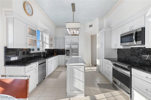 kitchen with a kitchen island, pendant lighting, white cabinetry, sink, and stainless steel appliances