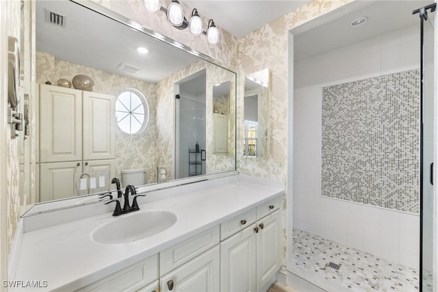 bathroom featuring vanity, toilet, and tiled shower