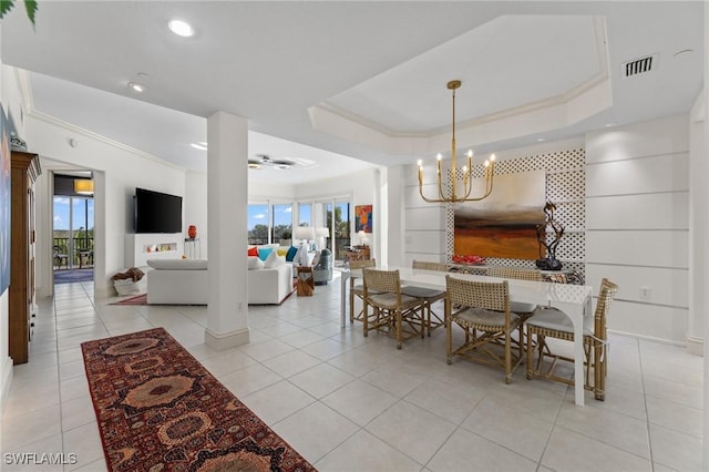 dining room with an inviting chandelier, light tile patterned floors, ornamental molding, and a raised ceiling