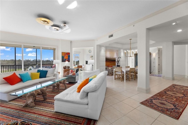 living room with an inviting chandelier, light tile patterned floors, and crown molding