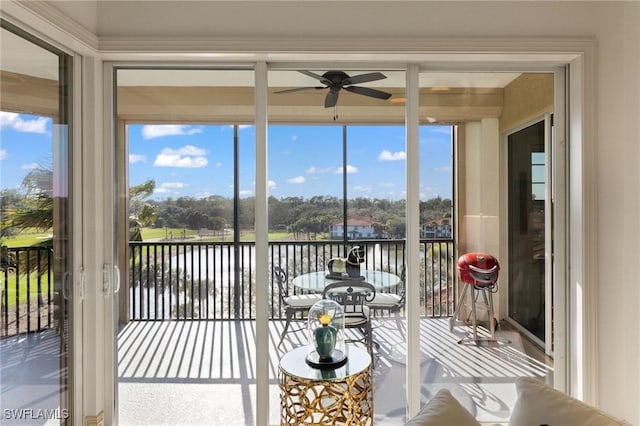 sunroom featuring a water view and ceiling fan