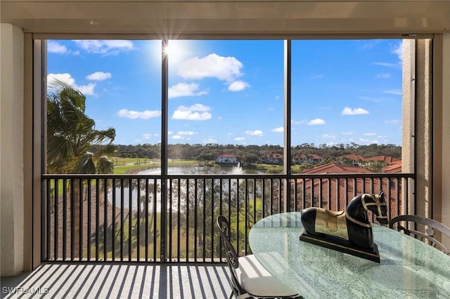 sunroom featuring a water view