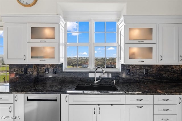 kitchen featuring white cabinetry, sink, tasteful backsplash, and dark stone countertops