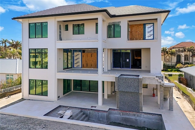 rear view of house with a patio area and stucco siding