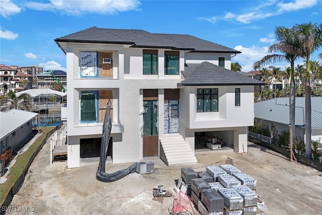 view of front of home with a carport, a patio area, and stucco siding