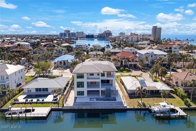 birds eye view of property featuring a water view and a city view