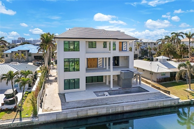 back of property featuring a balcony, fence, a residential view, stucco siding, and a patio area