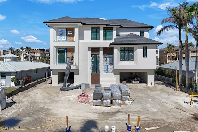 view of front facade with driveway, an attached garage, a residential view, and stucco siding