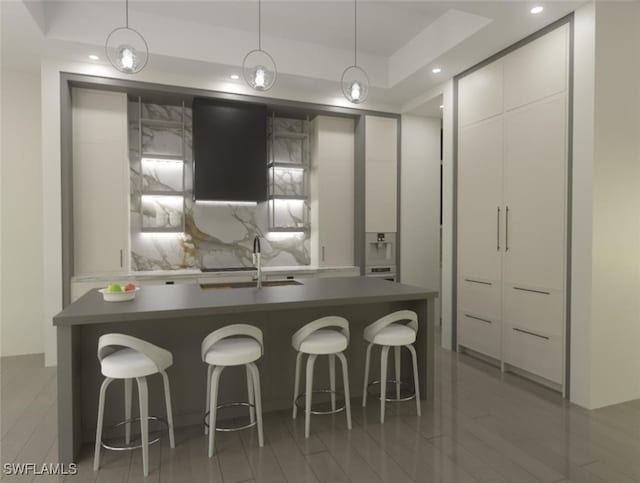 kitchen featuring a sink, white cabinetry, dark countertops, modern cabinets, and pendant lighting