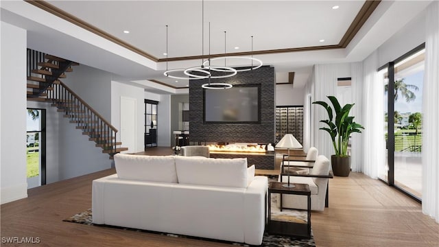 living room featuring recessed lighting, stairs, a tray ceiling, and ornamental molding