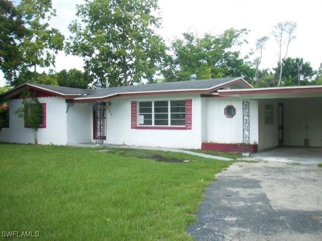 ranch-style house with a front yard and a carport