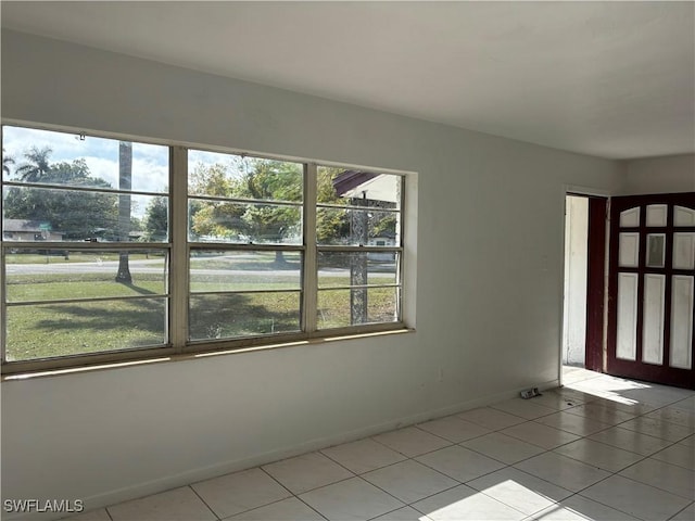 unfurnished room featuring light tile patterned floors and a healthy amount of sunlight