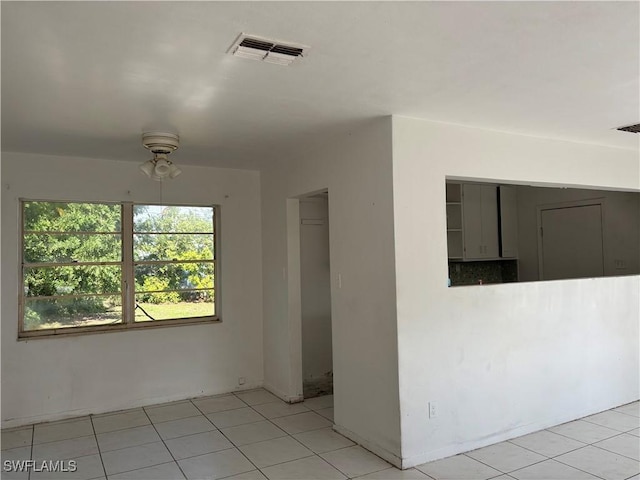 tiled spare room featuring ceiling fan