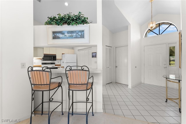 kitchen featuring an inviting chandelier, white appliances, high vaulted ceiling, and light tile patterned floors