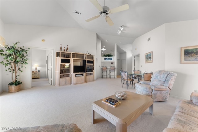 carpeted living room with ceiling fan and high vaulted ceiling