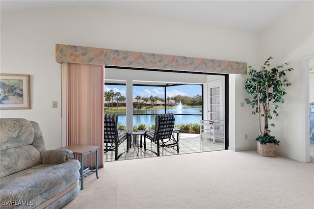 living area with lofted ceiling, light colored carpet, and a water view