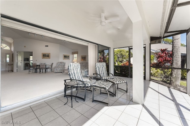 sunroom / solarium with ceiling fan, plenty of natural light, and vaulted ceiling