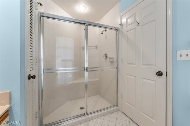 bathroom with a shower with door and tile patterned flooring