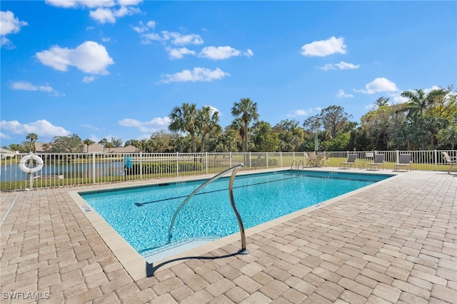 view of pool featuring a patio area and a water view