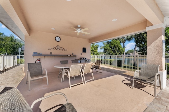 view of patio / terrace featuring a water view and ceiling fan