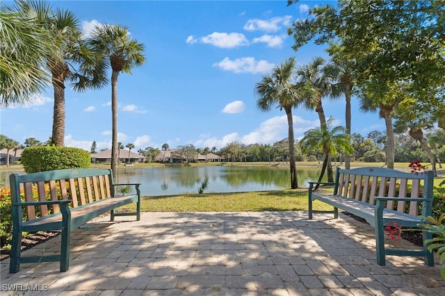 surrounding community with a water view and a yard