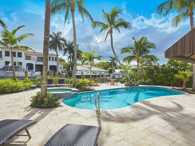 view of swimming pool featuring a hot tub and a patio