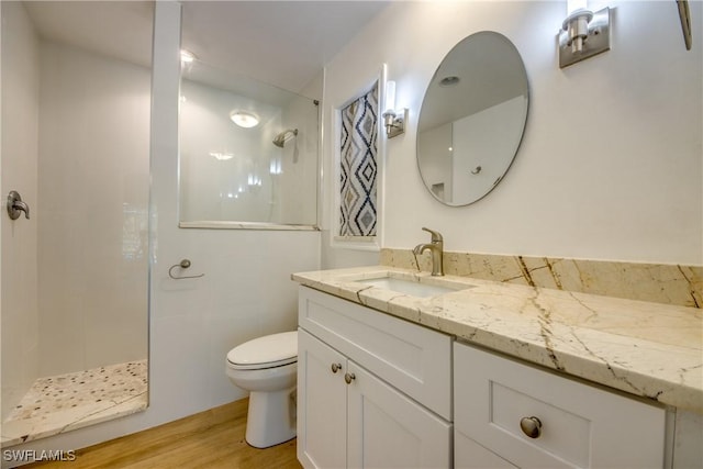 bathroom with walk in shower, vanity, toilet, and hardwood / wood-style floors