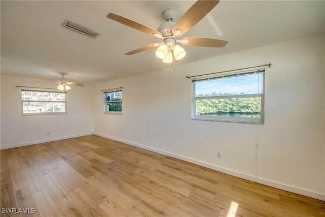 unfurnished room with ceiling fan, plenty of natural light, and light wood-type flooring