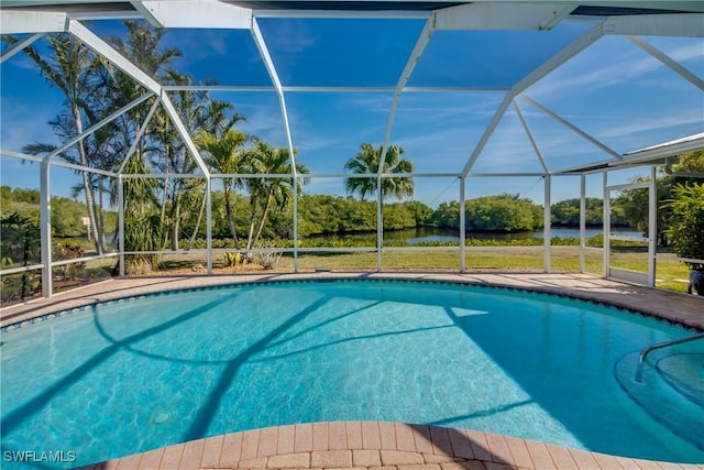 view of pool featuring glass enclosure and a water view