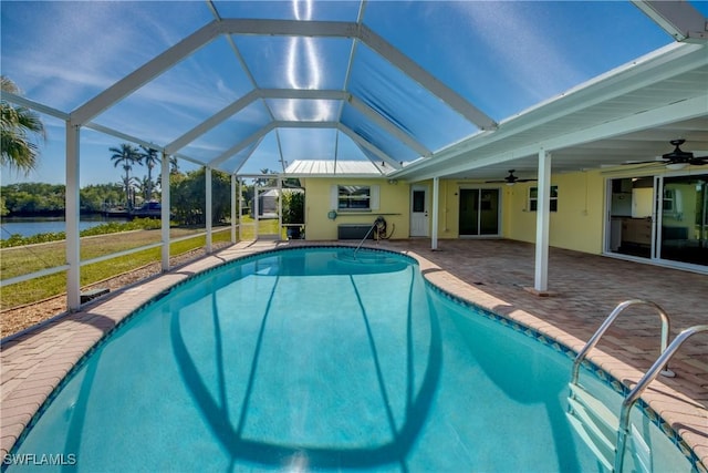 view of swimming pool featuring a lawn, a lanai, ceiling fan, a water view, and a patio area