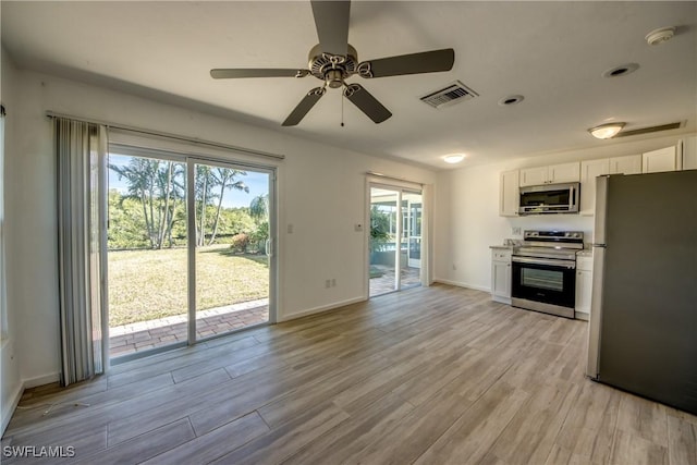 kitchen featuring ceiling fan, appliances with stainless steel finishes, light hardwood / wood-style flooring, and white cabinets