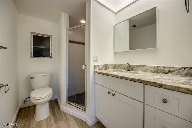 bathroom featuring a shower with door, vanity, wood-type flooring, and toilet