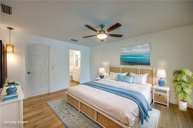 bedroom featuring ensuite bath, light hardwood / wood-style floors, and ceiling fan