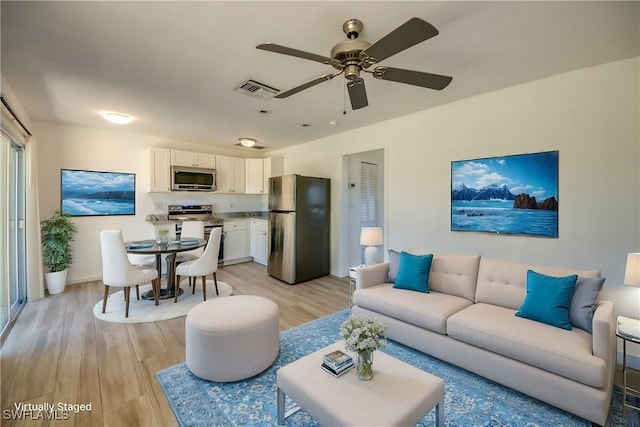 living room featuring ceiling fan and light hardwood / wood-style flooring