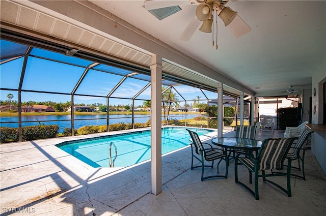 view of swimming pool featuring a lanai, a patio area, ceiling fan, and a water view