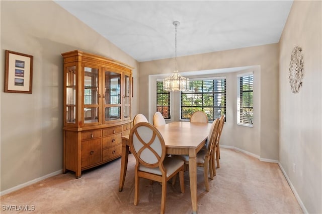 carpeted dining space with lofted ceiling and a notable chandelier