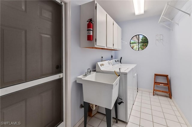 washroom with light tile patterned floors, cabinets, and washing machine and clothes dryer