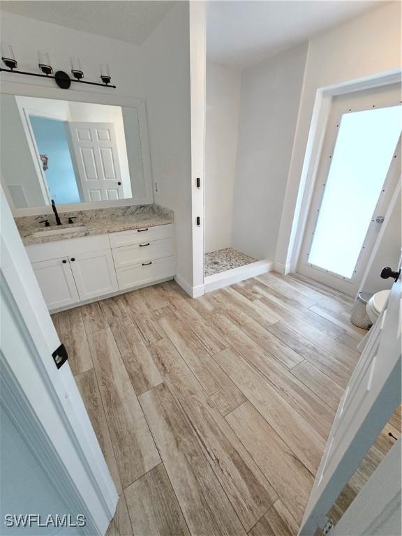 bathroom featuring vanity, hardwood / wood-style flooring, and a shower