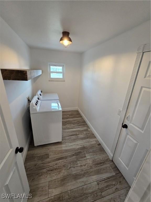 laundry room with dark wood-type flooring and separate washer and dryer