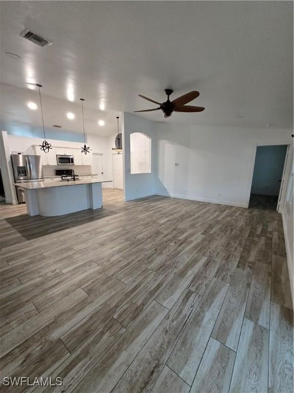 unfurnished living room with wood-type flooring and ceiling fan