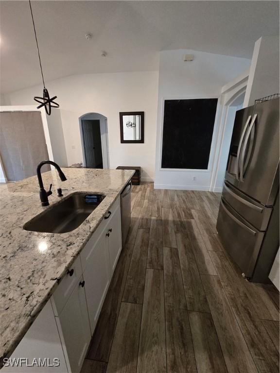 kitchen with dark hardwood / wood-style floors, sink, white cabinets, stainless steel appliances, and light stone countertops