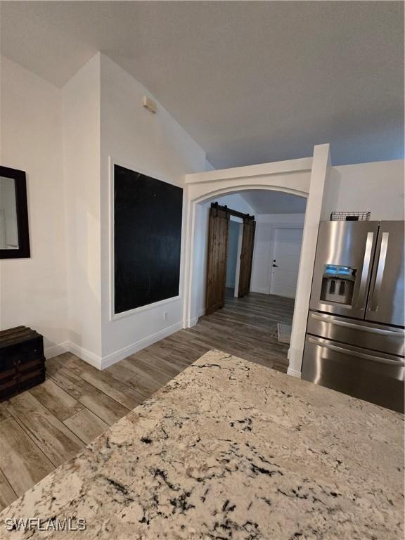 living room featuring lofted ceiling and hardwood / wood-style floors