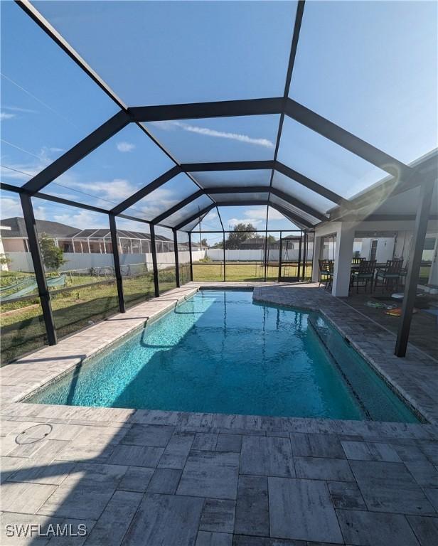 view of swimming pool featuring a patio and glass enclosure