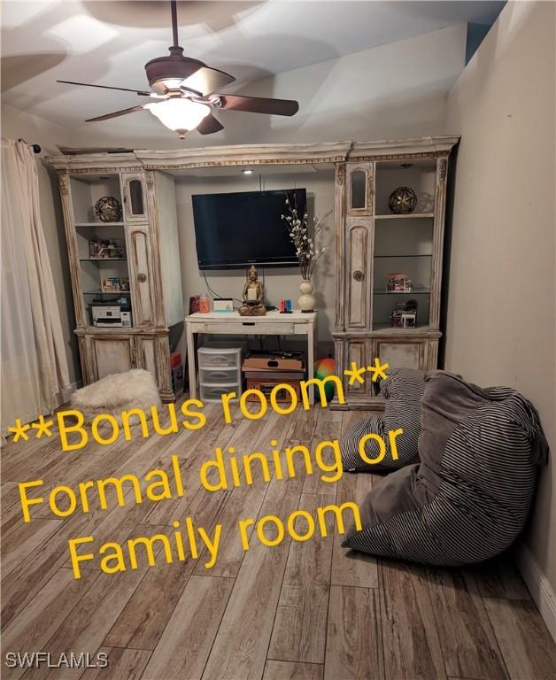 living room with wood-type flooring and ceiling fan