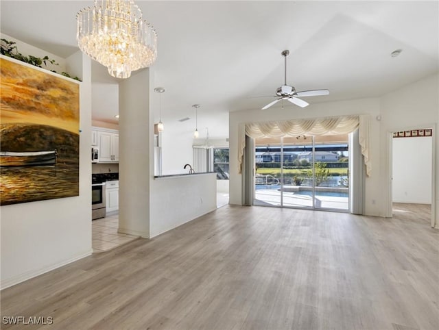 unfurnished living room with sink, ceiling fan with notable chandelier, and light hardwood / wood-style flooring