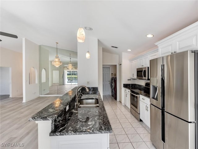 kitchen featuring white cabinetry, sink, dark stone countertops, and appliances with stainless steel finishes